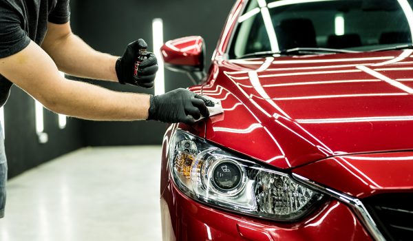 Car service worker applying nano coating on a car detail.
